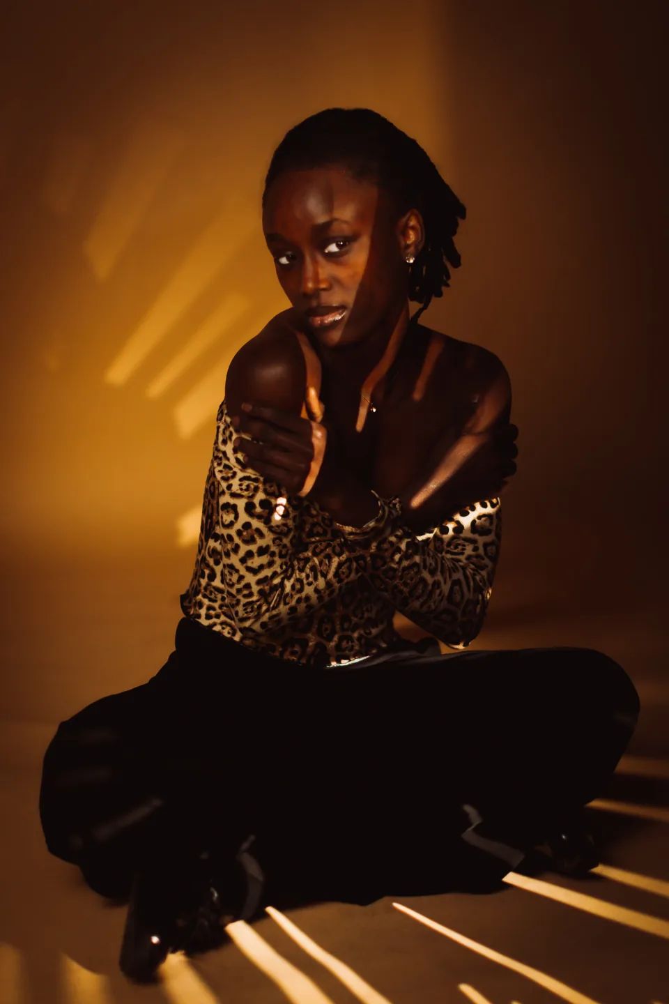 Editorial model portrait in leopard styling and dramatic golden light